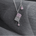 Silver popsicle necklace with pink and clear cubic zirconia on dark textured fabric