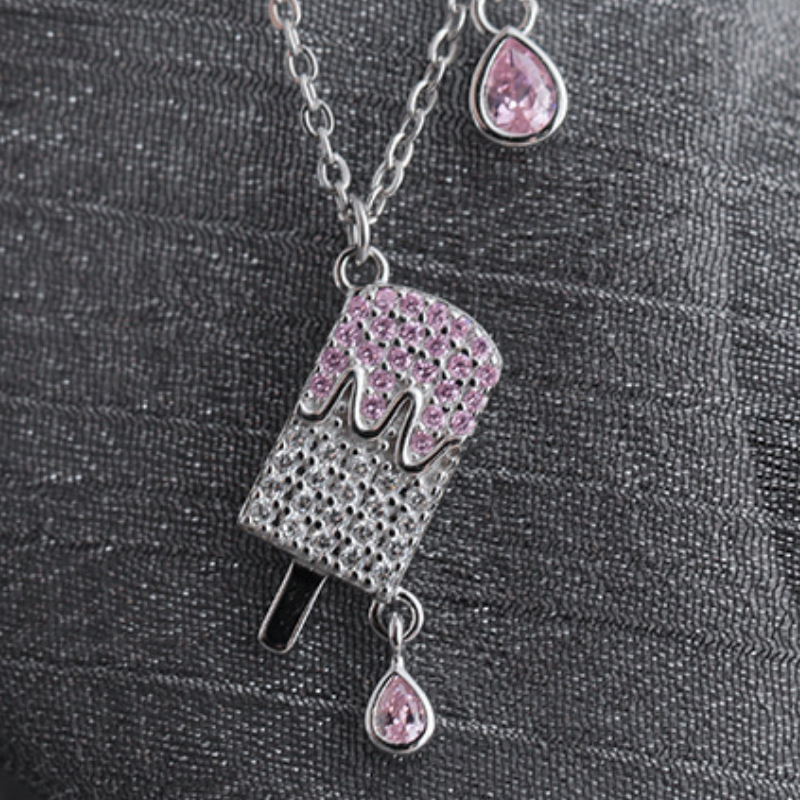 Angled view of the popsicle necklace on dark fabric