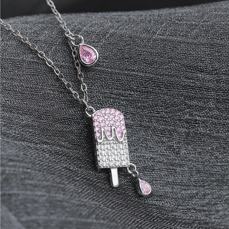 Front view of the popsicle pendant and pink teardrops on fabric