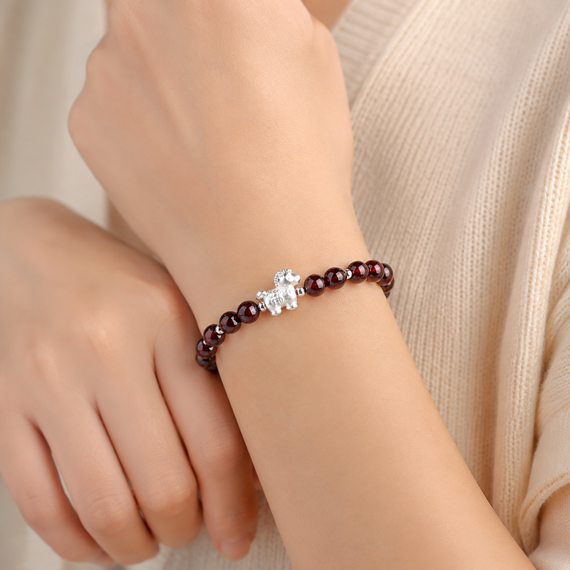 Lucky horse garnet bracelet worn on an adult woman's wrist