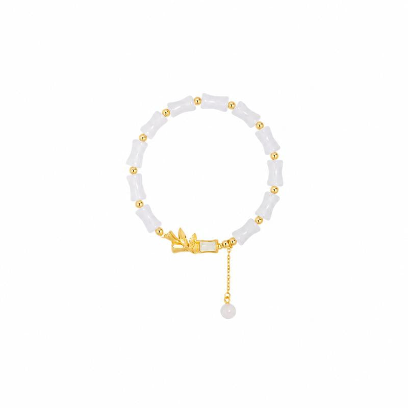 White chalcedony bamboo bracelet and jade tassel on a clean white background