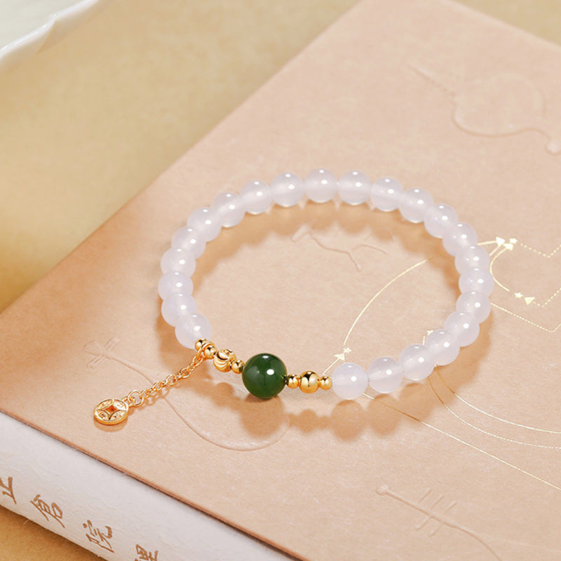 Angled product view of chalcedony bracelet on a warm book