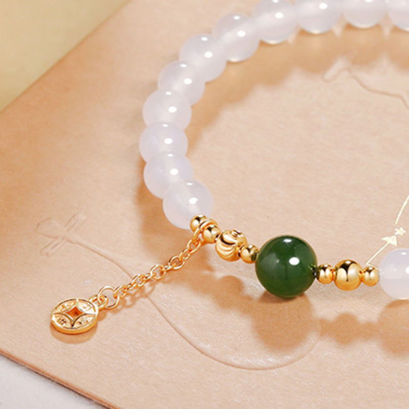 Close-up of green jasper bead spacers and coin charm tassel
