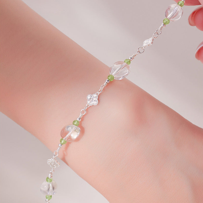 Hand held detail of clear quartz beads and clover links