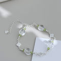 White quartz clover bracelet styled on a soft gray background