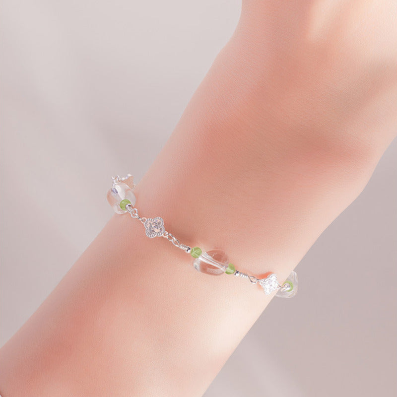 White quartz and peridot bracelet worn on a woman wrist