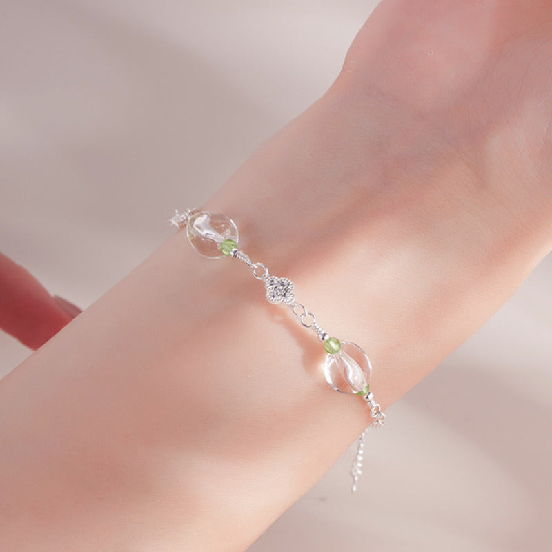 Close wrist view of white quartz and peridot bracelet