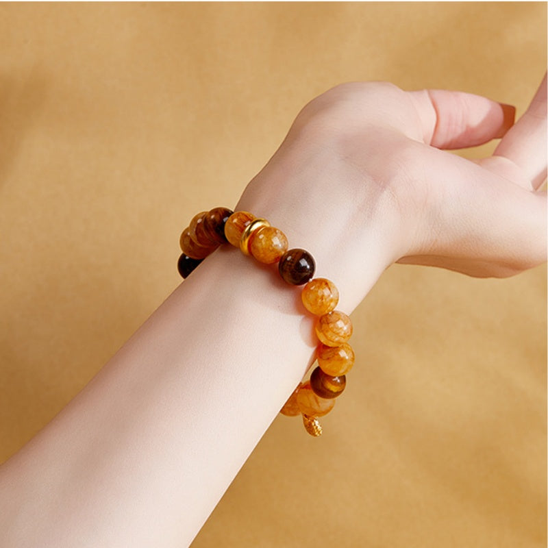 Yellow quartz and tiger's eye bracelet worn on a woman's wrist
