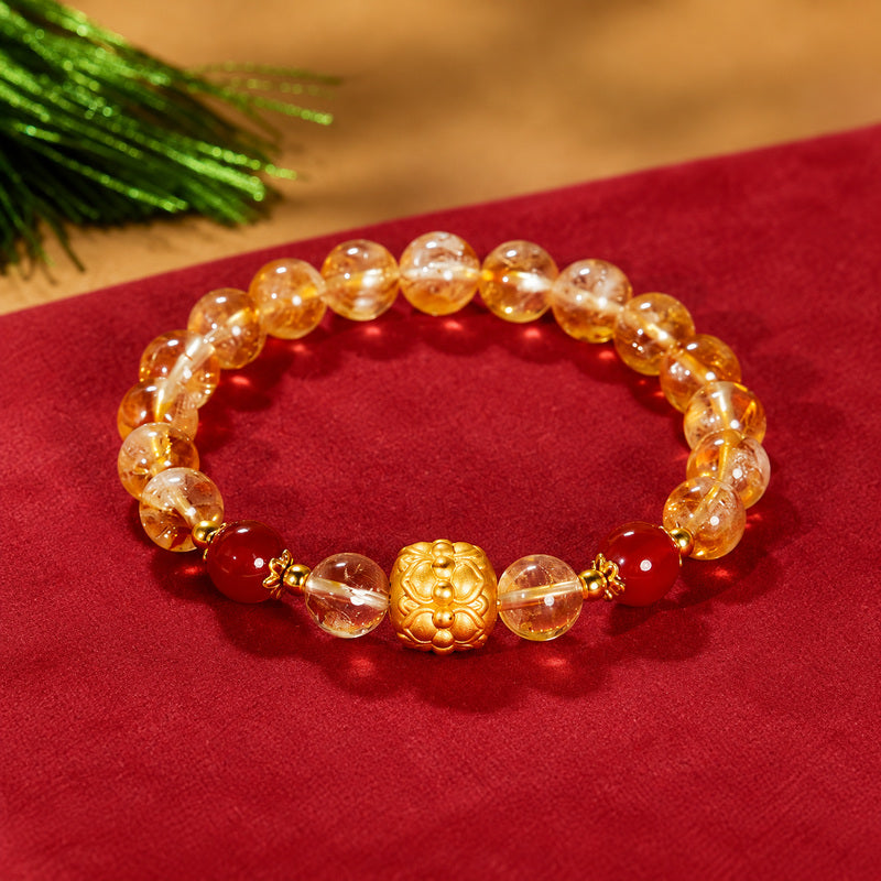 Overhead view of yellow quartz bracelet with two red agate accents