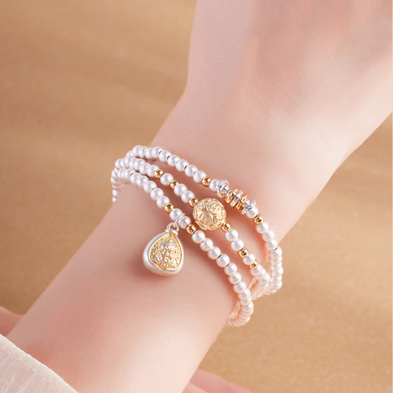 Yellow Wealth Deity silver bracelet worn as a triple wrap