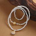 999 silver Yellow Wealth Deity triple-wrap bracelet on warm sand