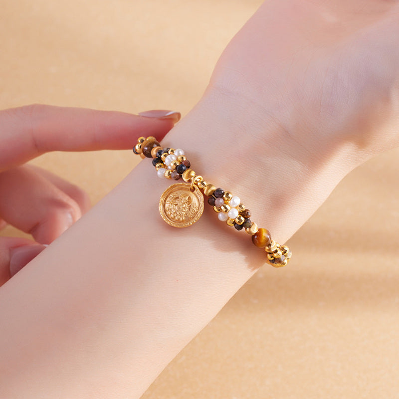 Close view of Yellow Wealth Deity pietersite pearl bracelet on the wrist