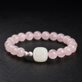 White jade Zaki Lhamo rose quartz bracelet on dark slate