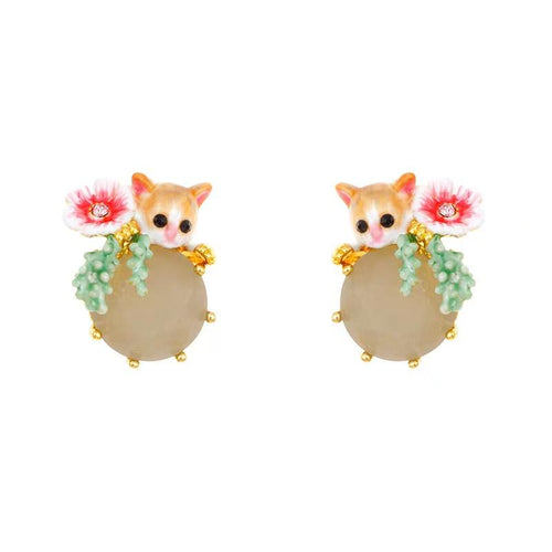 Pair of orange cat earrings with pink flowers, green leaves, and round gray rhinestone bodies on white