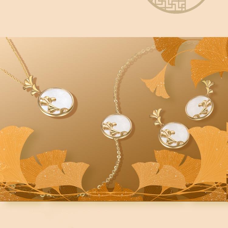 Complete ginkgo leaf pearl charm set arranged among decorative golden leaves on beige