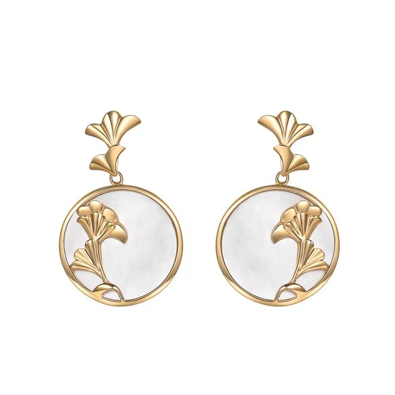 Pair of matching gold ginkgo leaf and pearl white charms displayed on white