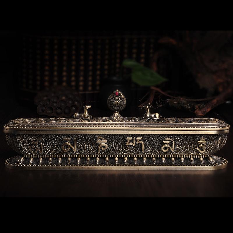 Antique bronze incense burner showing engraved script, raised lid details, and animal-shaped decorative elements