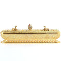Gold-tone Tibetan incense burner with elongated rectangular body, decorative lid, and Buddhist motifs on white